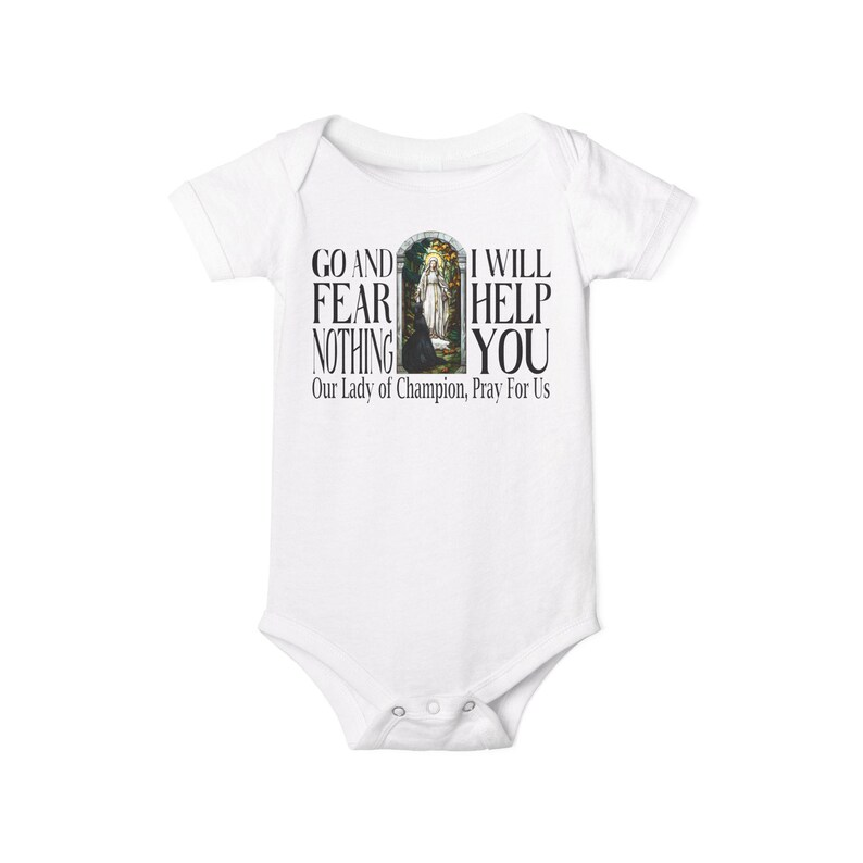 May include: A white short-sleeved baby bodysuit featuring a graphic print of a religious figure in an archway. The text reads: GO AND FEAR NOTHING I WILL HELP YOU Our Lady of Champion, Pray For Us. The garment has a crew neckline and snap closures.