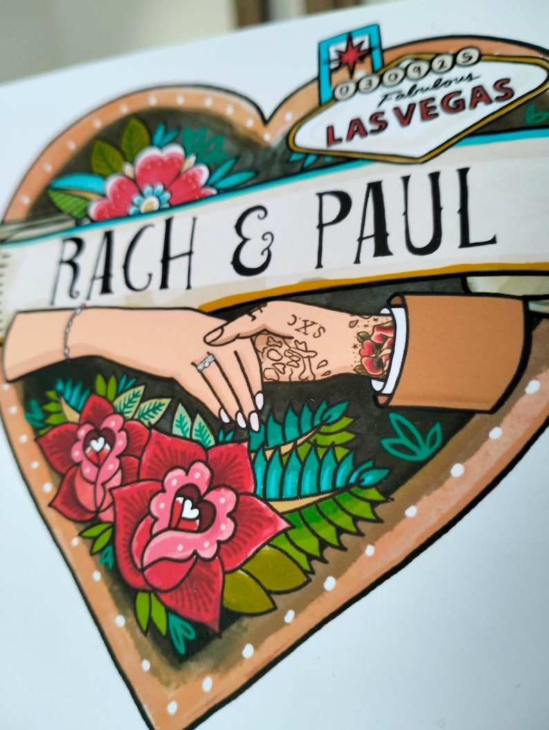 May include: A heart-shaped illustration featuring the text RACH & PAUL and a Las Vegas sign graphic. The design depicts two hands holding each other, one with a ring and bracelet, the other with tattoos, surrounded by red roses and green leaves.