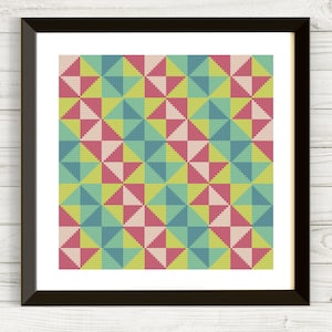 Peut inclure: Une impression encadrée d'un motif géométrique avec des triangles répétés dans des tons de rose, jaune et bleu.