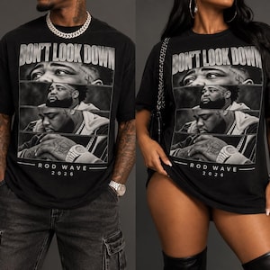 May include: A black short-sleeve t-shirt featuring a graphic print with the text DON'T LOOK DOWN at the top and ROD WAVE 2026 at the bottom. The graphic consists of three stacked black and white photographic panels of a man with a beard.
