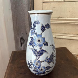 Vintage vase with inlaid blue flower and foliage.