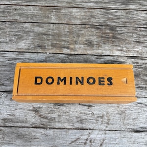 True vintage wooden dominoes in a box: imperfectly perfect, unique black hand painted dominoes, board game party.