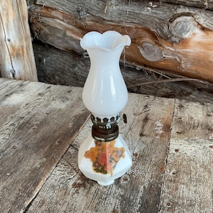 Vintage White ceramic oil lamp with floral design.