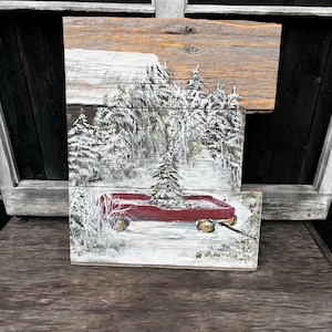 Wandel door het bos op zoek naar de kerstboom. Met de rode kar. Handgeschilderde wanddecoratie op gerecycled hout. Kersttijd.