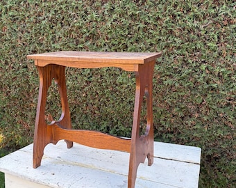 Vintage  wood side table with  Art Nouveau and traditional influences. Features openwork cutouts along the sides.