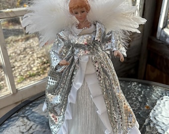 Holiday Time Angel Tree Topper Grey/Silver 12’’. Porcelain hands and face. Feather wings. Has been repaired at the neck and wings. See photo