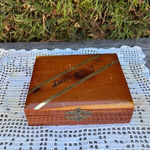 May include: A vintage wooden box with a hinged lid. The box is rectangular with a warm brown finish and gold-coloured accents. The words "Dear Diary" are written across the top. The box has a metal clasp and the name "JACKMAN" is visible.