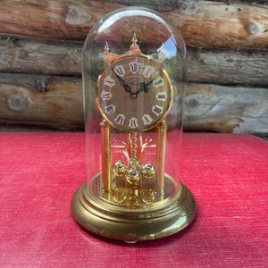 Vintage Rensie Clock Doomed Lid anniversary Table Clock Quartz Spinning Pendulum Rare West Germany. Needs to be repaired.
