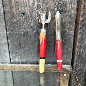 Deux éplucheurs d&#39;ustensiles de cuisine vintage, ouvre-boîte, poignée rouge, cuisine campagnarde de ferme.