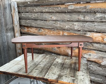 MESA DE CENTRO VINTAGE DE MEDIADOS DE CENTRO Moderna de madera marrón, tabla de surf retro danesa de los años 60. Patrón de flores de metal en la parte superior de las patas de la mesa.