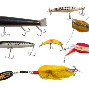 May include: A collection of vintage fishing lures in various shapes and colors. The lures include a black torpedo-shaped lure, a white and black spotted lure with a propeller, and a yellow lure with a red tail. Each lure has multiple hooks.