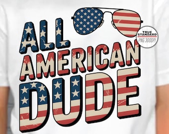 Może przedstawiać: Biała koszulka z napisem "ALL AMERICAN DUDE" w kolorze czerwonym, białym i niebieskim, z motywem okularów przeciwsłonecznych z flagą amerykańską. Koszulka jest noszona przez osobę w czerwonej czapce z daszkiem.