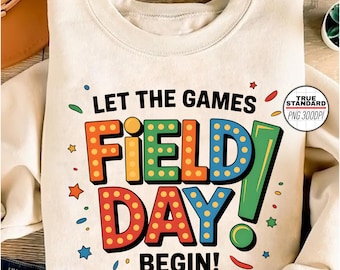 Może przedstawiać: Biały t-shirt z tekstem "Let the games begin!" i kolorową grafiką słów "Field Day" w stylu retro.