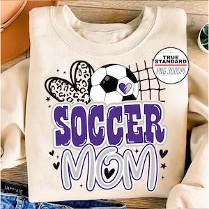 May include: Purple and gray graphic design with the text "Soccer Mom" and a soccer ball with a leopard print heart.