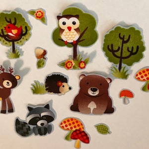Puede incluir: Un conjunto de pegatinas con temática de bosque, que presenta varios animales y elementos forestales. Incluye un oso pardo, un ciervo, un mapache, un erizo, un búho, árboles, setas y un pájaro. Las pegatinas tienen un estilo de dibujos animados.