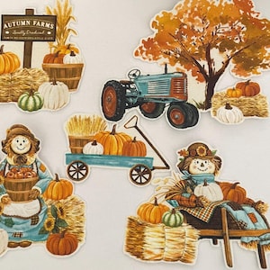 Op de afbeelding: Een verzameling herfstthema papieren decoraties. De set bevat pompoenen, hooibalen, vogelverschrikkers, een tractor en een boom. Het kleurenpalet bevat warme herfsttinten van oranje, bruin en groen. Het bord leest "Autumn Farms".