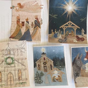 May include: A selection of Christmas cards with religious themes. The cards show illustrations of the Three Wise Men, the Nativity scene, a church with a wreath, and a star above a stable. The colour scheme includes beige, blue, and gold.