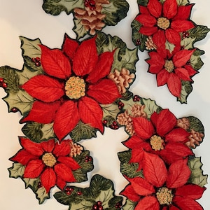 May include: A set of six red poinsettia flower fabric appliques with green leaves and brown pine cones. The appliques are perfect for adding a festive touch to any craft project.