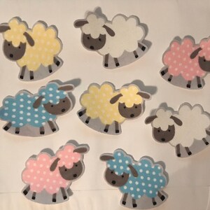 May include: Eight felt sheep appliques in various colors and patterns. The sheep are white, yellow, blue, and pink with white polka dots. The sheep have brown faces and black legs.