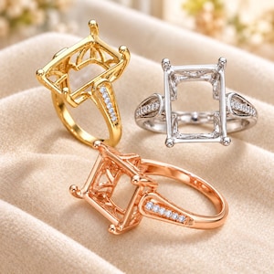 May include: Three ring settings in gold, silver, and rose gold tones. Each ring features a rectangular prong setting for a gemstone and a band accented with small, clear pavé stones along the shoulders, showcasing a metallic finish.