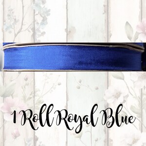 Puede incluir: Un rollo de cinta azul real. La cinta es de un solo color y tiene un ligero brillo.