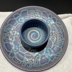 May include: A blue and white ceramic serving dish with a smaller bowl in the center. The dish has a decorative design of swirling lines and flowers.