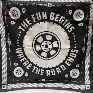 May include: Black and white bandana with a tire graphic in the center and the text "THE FUN BEGINS WHERE THE ROAD ENDS." The design includes tire rims, the words "ON X OFFROAD," and decorative elements.