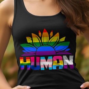 Könnte beinhalten: Schwarzes Tanktop mit einem farbenfrohen Sonnenblumen-Design. Die Sonnenblumenblätter sind in Regenbogenfarben gehalten, und das Wort "HUMAN" ist in Regenbogenfarben und der Transgender-Flagge aufgedruckt. Das Tanktop ist aus weichem Material.