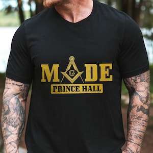 May include: Black t-shirt with a gold graphic of a compass and the text "MADE PRINCE HALL".