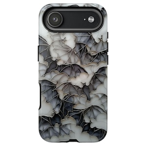 May include: A smartphone case with a repeating pattern of stylized bats in grey and white. The case has a black camera housing and a glossy finish, offering a spooky yet elegant design.