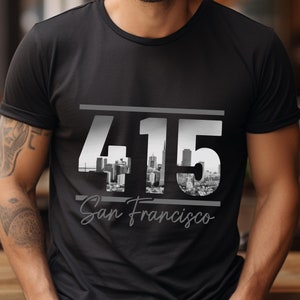 May include: Black t-shirt with a white graphic of the San Francisco skyline and the area code 415.