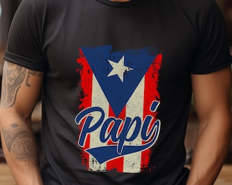 May include: Black t-shirt with a distressed Puerto Rican flag design and the word "Papi" in a vintage-style font.