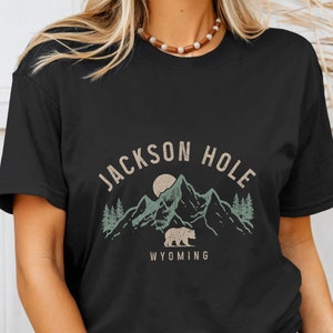 May include: Black t-shirt with a graphic design of mountains, a bear, and the text "Jackson Hole Wyoming".