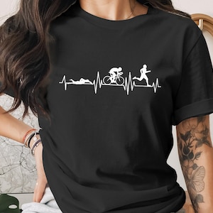 Black t-shirt with a white graphic of a heartbeat line incorporating swimming, cycling, and running figures.