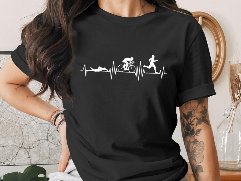 Black t-shirt with a white graphic of a heartbeat line incorporating swimming, cycling, and running figures.