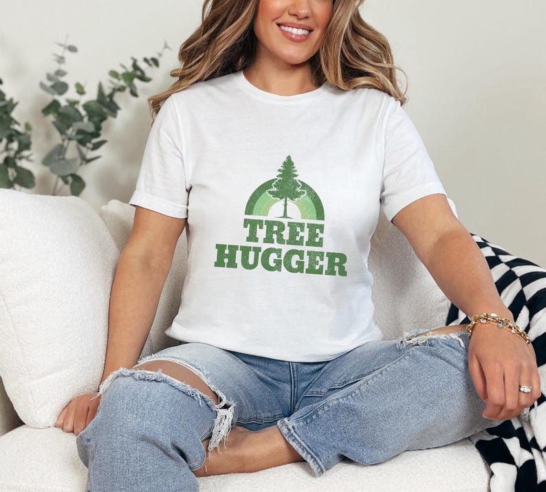 May include: White t-shirt with a green tree and rainbow graphic and the text "Tree Hugger".