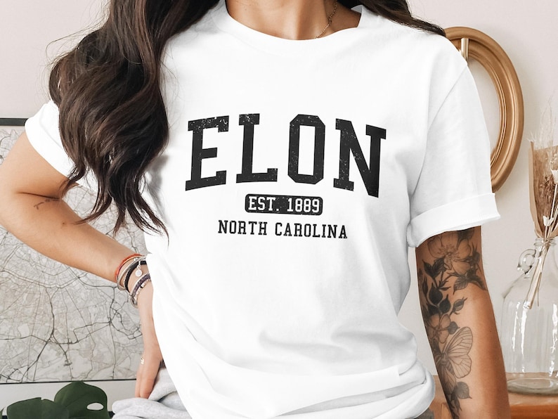 White t-shirt with "ELON EST. 1889 NORTH CAROLINA" in black block letters.