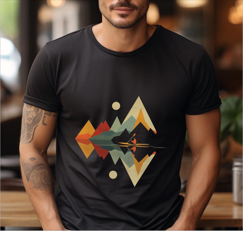 May include: A black t-shirt with a geometric design of mountains and a lake with a canoe in the middle. The design is in shades of orange, yellow, green, blue, and red.