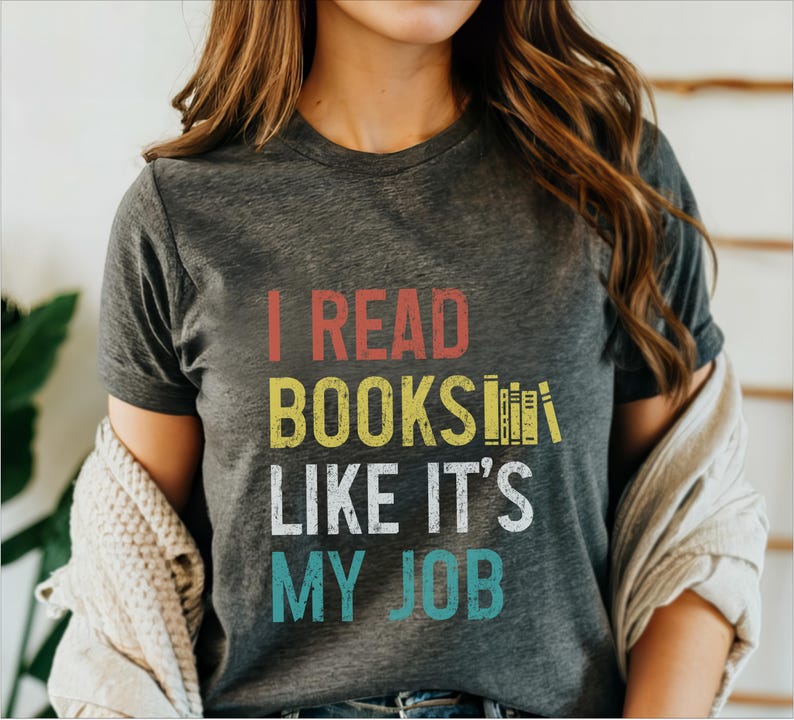 May include: A grey t-shirt with the text "I read books like it's my job" in a vintage style font. The text is in red, yellow, white, and blue.