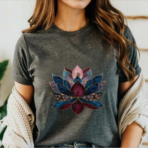 May include: A dark gray t-shirt with a colorful lotus flower design. The flower is made up of shades of blue, purple, pink, and gold.