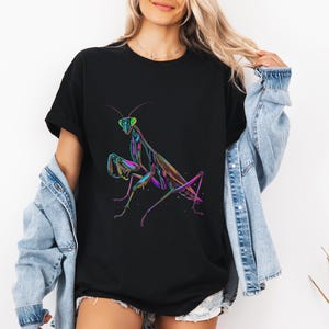 May include: A black t-shirt with a colorful graphic of a praying mantis. The mantis is outlined in neon green, pink, and blue.