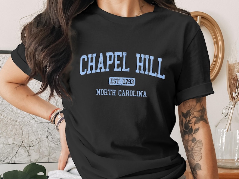 Black t-shirt with light blue "Chapel Hill Est 1793 North Carolina" text.