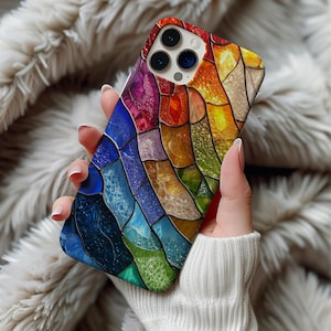 Könnte beinhalten: Eine farbenfrohe Handyhülle mit einem Buntglas-Design. Die Hülle zeigt eine lebendige Anordnung von Farben, darunter Rot, Orange, Gelb, Grün, Blau und Lila, in einem Mosaikmuster. Die Handyhülle hat eine glänzende Oberfläche.