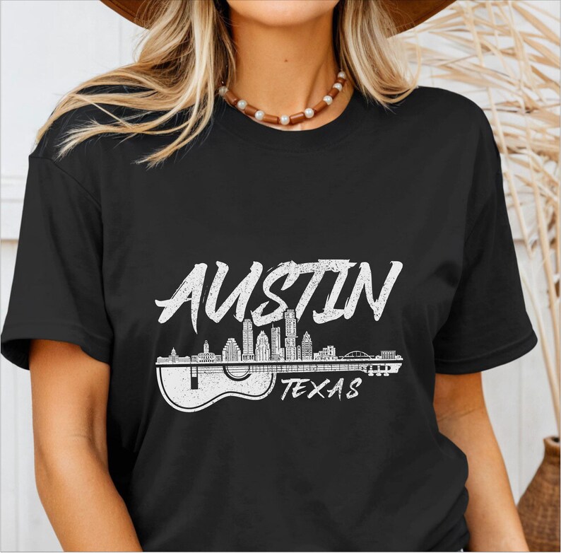 May include: Black t-shirt with a white graphic of the Austin, Texas skyline with a guitar silhouette. The text "Austin Texas" is printed below the skyline.