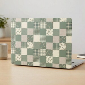 Op de afbeelding: Een laptopsticker met een patchworkontwerp van afwisselende vierkanten in saliegroen, crème en wit. Het patroon bevat effen kleuren, kleine bloemenprints en diverse ruit- of vichy-patronen die in een raster zijn gerangschikt.