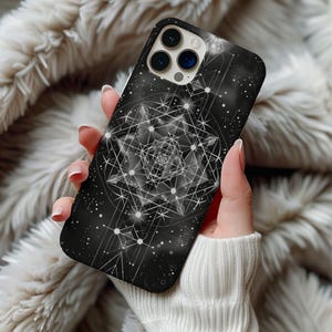 May include: Black phone case with a geometric design featuring interconnected lines and dots. The case has a glossy finish and a dark background with a celestial pattern. The design is in shades of white and gray.