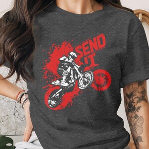 Dark t-shirt with red graphic of motocross rider mid-air, "SEND IT" text.