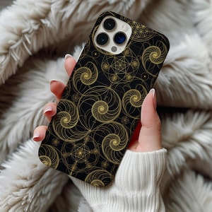 May include: A black smartphone case featuring a repeating gold-coloured geometric pattern of interlocking spirals and circular shapes. The design covers the entire back of the case, which includes a cutout for a triple-lens camera system.