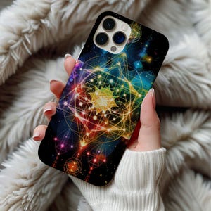 May include: A black phone case featuring a colorful geometric design with a celestial theme. The design incorporates various shapes and lines in shades of yellow, orange, blue, and purple, creating a vibrant and intricate pattern. The case has a glossy finish.