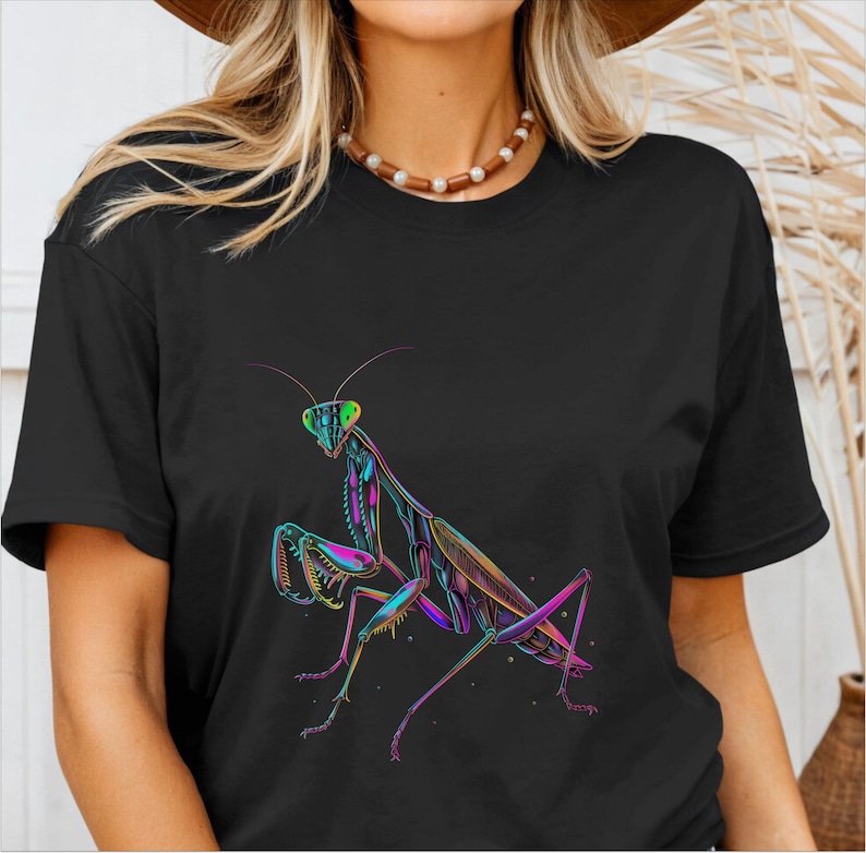 May include: A black t-shirt with a colorful graphic of a praying mantis. The mantis is outlined in pink, green, and blue.